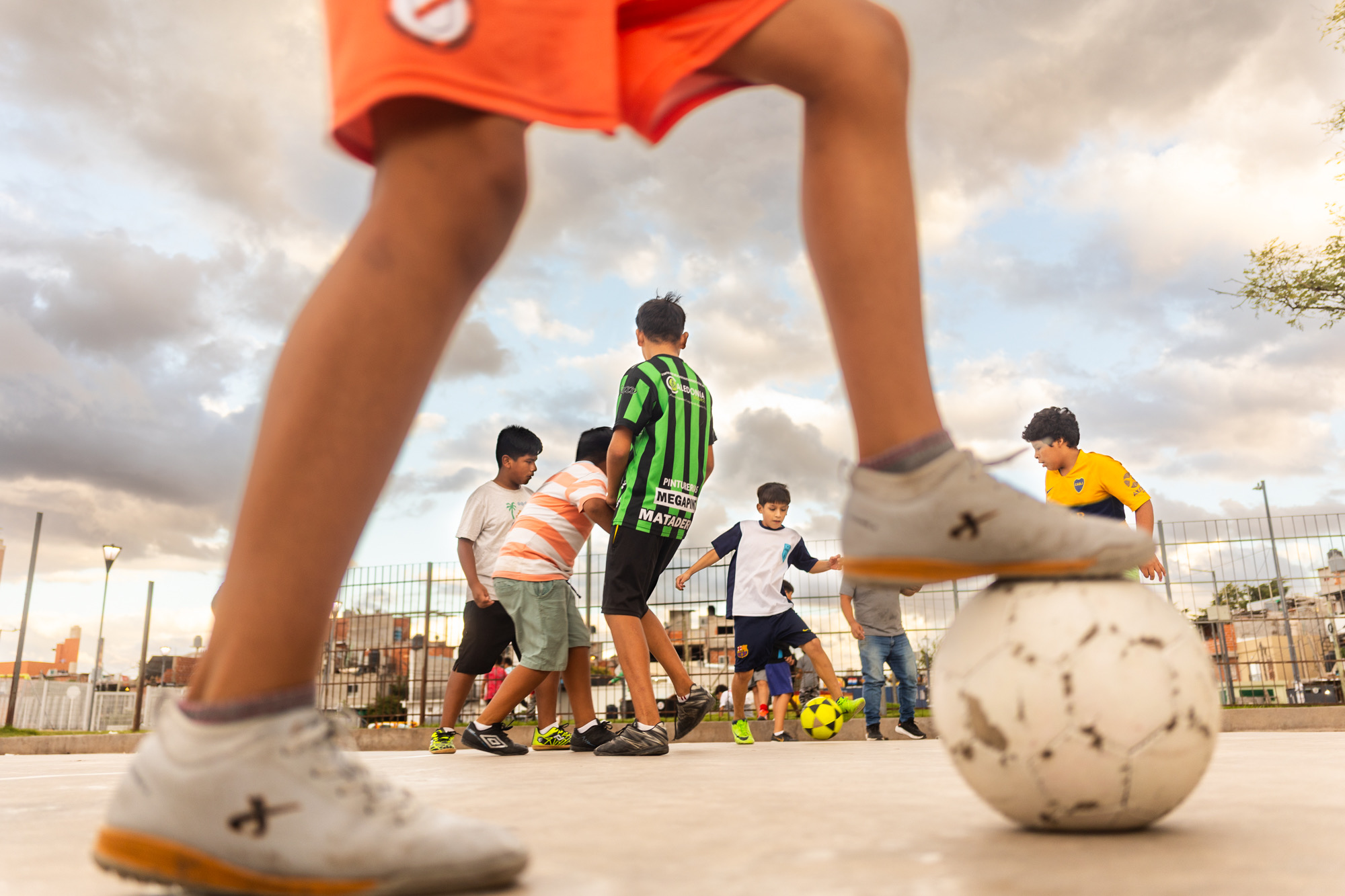 Image of boys playing soccer, with one's foot on the soccerball